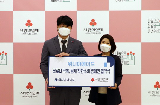 김준 위니아에이드 유통사업본부장(왼쪽)과 김경희 사랑의열매 사회복지공동모급회 사회공헌본부장이 지난 29일 협약식 후 기념사진을 촬영하고 있다. <위니아딤채 제공>